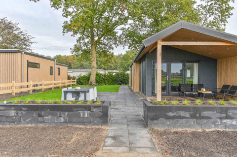 Casa vacanza moderna al Drentse Weelde, Drenthe, Paesi Bassi, con patio, giardino e area salotto esterna.