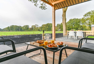 Colazione in terrazza con cornetti e succo, vista campi verdi al Drentse Weelde, Drenthe, Paesi Bassi.