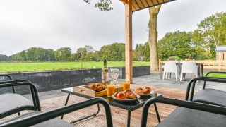Ontbijt op het terras met croissants en sap, uitkijkend op weilanden bij Drentse Weelde, Drenthe.