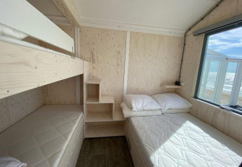 Lyst strandhus med køjeseng og dobbeltseng, store vinduer med udsigt til stranden i Dishoek, Zeeland.