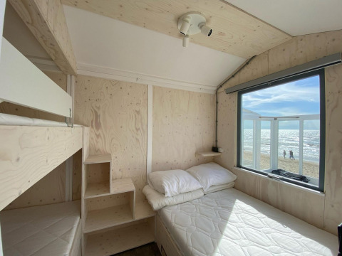 Lyst træinteriør i Beach house Dishoek 345/346 med udsigt til stranden og havet i Zeeland, Holland.