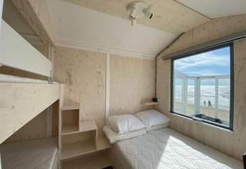 Lyst træinteriør i Beach house Dishoek 345/346 med udsigt til stranden og havet i Zeeland, Holland.