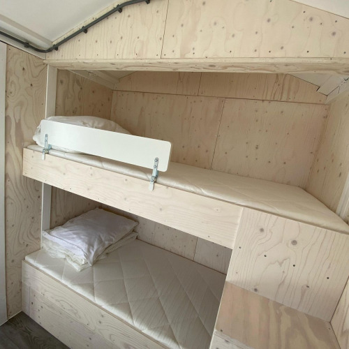 Bright bunk bed room at Beach house 'Dishoek 345/346', with simple wooden paneling and minimalist decor.