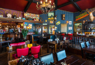 Indvendigt billede af en hyggelig bar eller restaurant på en feriepark med glamping-muligheder.