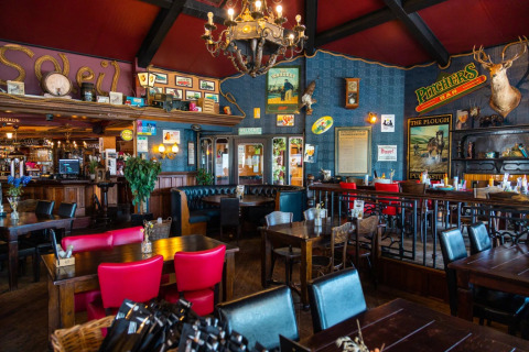 Intérieur d’un pub-restaurant chaleureux dans un parc de vacances proposant un hébergement glamping.