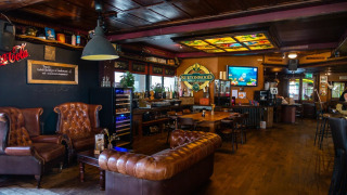 Area lounge accogliente con divani in pelle e bar in un glamping di un parco vacanze, decorazioni in legno.