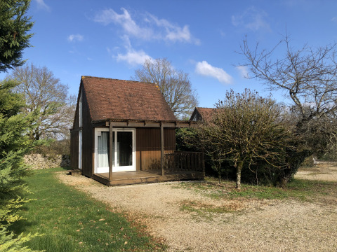 Ein kleines Ferienhaus mit Holzveranda im Ferienpark Camping le Roc in Occitanie, Frankreich.
