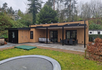 Udendørsbillede af Wellness Cottage 6p på De Thijmse Berg i Holland med træfacade og stor terrasse.