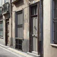 Callejón estrecho con antiguas fachadas y ventanas enrejadas cerca de Rocamadour, Occitanie, Francia.