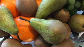 Primer plano de peras, kiwis, naranjas y uvas verdes en un frutero en Hofparken De Bergvennen.