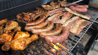 Grill mit Würstchen, Hähnchenschenkeln und Rippchen auf Camping De La Vallée, Luxemburg, Belgien.
