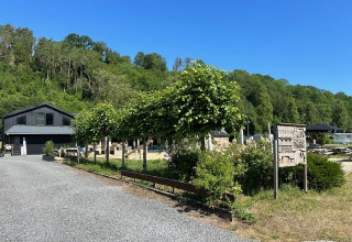 Blick auf Camping De La Vallée, einen Ferienpark in Belgien Luxemburg, umgeben von Natur und Bäumen.
