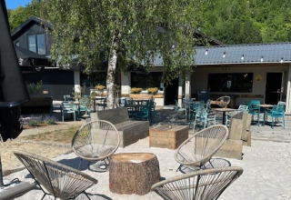 Outdoor seating with modern chairs and sandy ground at Camping De La Vallée, Belgium Luxembourg, Belgium.