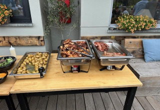 Tavolo buffet con carne, patate e insalata al Camping De La Vallée, Belgio Lussemburgo.