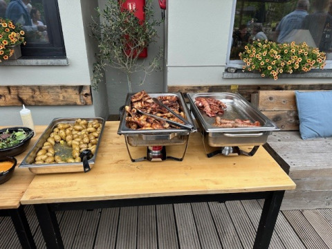 Mesa buffet con carne asada, papas y ensalada en Camping De La Vallée, Bélgica Luxemburgo.