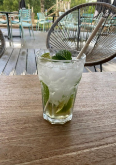 Ein Mojito-Glas mit Limetten und Minze auf Holztisch, Camping De La Vallée, Luxemburg, Belgien, draußen.