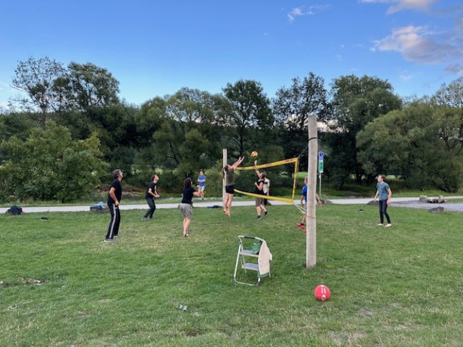 Mensen spelen volleybal op het gras bij Camping De La Vallée in Belgisch Luxemburg.