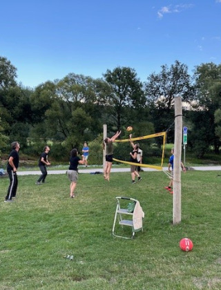 Personas jugando voleibol al aire libre en un campo de césped en Camping De La Vallée, Bélgica Luxemburgo.