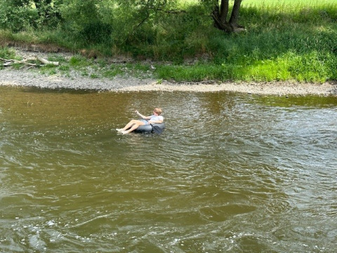 Una persona galleggia tranquillamente su una ciambella gonfiabile in un fiume vicino a Durbuy, Lussemburgo, Belgio.