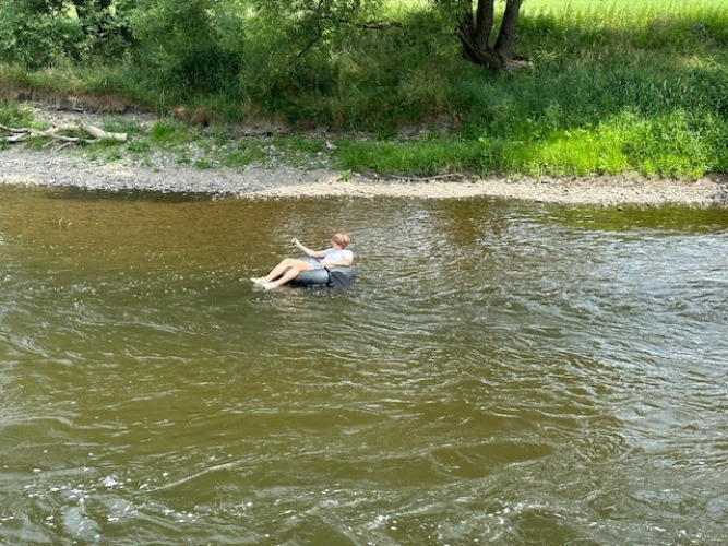 A person floats leisurely on an inflatable tube down a river near Durbuy, Luxembourg province, Belgium.