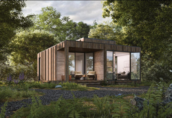 Een moderne houten lodge met grote ramen in het bos, omgeven door weelderige groene beplanting.