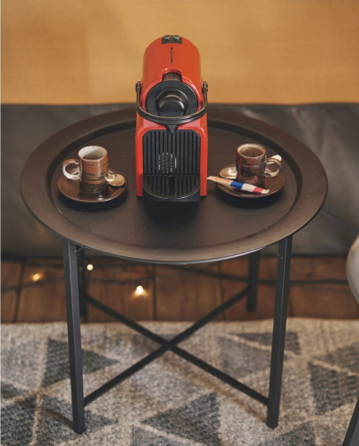 Cafetera roja y dos tazas de espresso sobre una mesa negra en una tienda safari del Camping d'Artagnan, Francia.