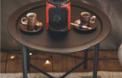 Rote Kaffeemaschine und zwei Espressotassen auf einem schwarzen Tisch im Safarizelt auf Camping d'Artagnan, Frankreich.