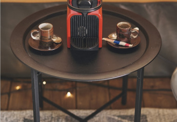 Rode koffiemachine met twee espressokopjes op een zwart tafeltje in een safaritent bij Camping d'Artagnan, Frankrijk.