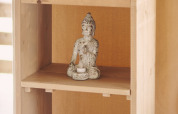 Étagère en bois dans une tente safari avec statue de Bouddha, bougies LED et jeu Scrabble en France.
