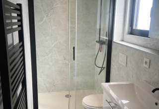Baño moderno en el chalet Sea Pearl de Vakantiepark de Zeeuwse Parel, con ducha de cristal y lavabo.