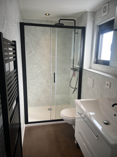 Baño moderno en el chalet Sea Pearl de Vakantiepark de Zeeuwse Parel, con ducha de cristal y lavabo.