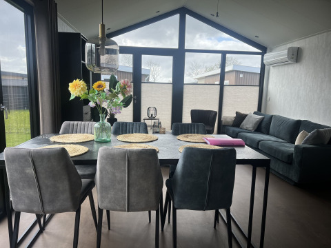 Salón y comedor moderno en el chalet Sea Pearl de Vakantiepark de Zeeuwse Parel en los Países Bajos.