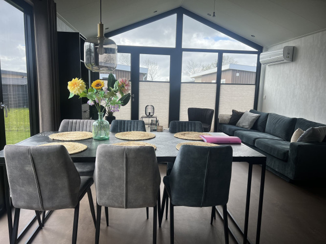 Salón y comedor moderno en el chalet Sea Pearl de Vakantiepark de Zeeuwse Parel en los Países Bajos.