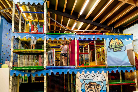 Kinderen spelen in een indoor speeltuin in vakantiepark Beloofde Land in Gelderland, Nederland.