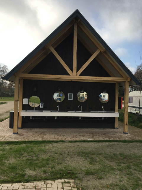 Buiten afwasplaats met vier ronde spiegels en wasbakken in vakantiepark Beloofde Land, Gelderland, Nederland.