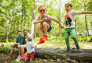 Familie beleeft plezier in het bos bij Beloofde Land vakantiepark, Gelderland, Nederland, met spelende kinderen.