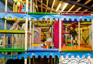 Børn leger i et farverigt indendørs legecenter i ferieparken Beloofde Land i Gelderland, Holland.