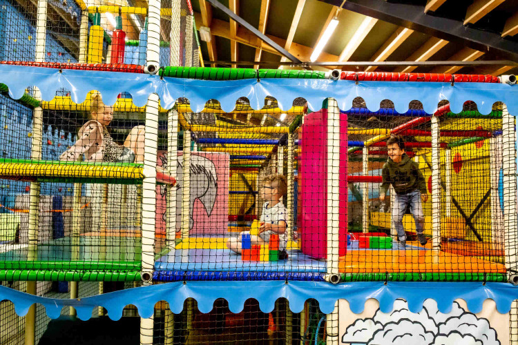 Kinder spielen in einem bunten Indoor-Spielcenter im Ferienpark Beloofde Land, Gelderland, Niederlande.