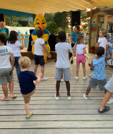 Niños disfrutan de una animación con mascota en Camping Paradis La Bretonniere en Pays de la Loire, Francia.