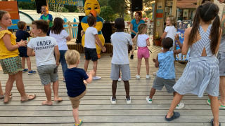 Niños disfrutan de una animación con mascota en Camping Paradis La Bretonniere en Pays de la Loire, Francia.