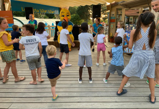 Kinder nehmen an einer unterhaltsamen Aktivität mit Maskottchen im Camping Paradis La Bretonniere in Frankreich teil.