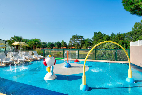 Piscina infantil y parque acuático con juegos de agua y tumbonas en Camping Paradis La Bretonniere, Pays de la Loire.