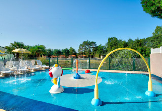 Spetterbad en kinderwaterpark met ligstoelen bij Camping Paradis La Bretonniere in Pays de la Loire, Frankrijk.