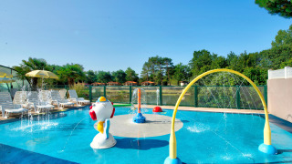 Piscina infantil y parque acuático con juegos de agua y tumbonas en Camping Paradis La Bretonniere, Pays de la Loire.