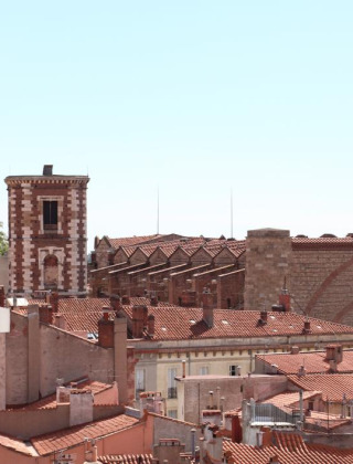 Blick über Dächer und historische Gebäude in der Nähe von Vauvert, Okzitanien, Frankreich, an einem sonnigen Tag.