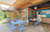 Udendørs terrasse og moderne køkkenområde på Chalet Evasion, glampingophold omgivet af natur.