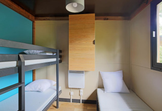 Kamer met stapelbed en eenpersoonsbed in Chalet Evasion glamping, modern interieur en raam.