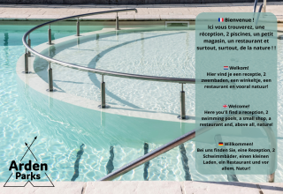 Piscina con barandilla y cartel de bienvenida de Arden Parks en varios idiomas, incluido el inglés.