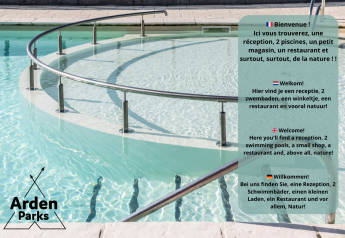 Piscina con corrimano e informazioni di benvenuto Arden Parks in diverse lingue, incluso l’inglese.