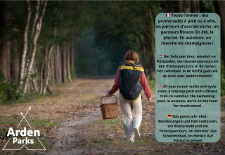 Persoon met rugzak en mand wandelt in bos, Arden Parks promoot jaarrond amusementsactiviteiten.
